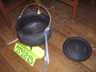 Cauldron with 'TIPS' sign, small brass bell, lid