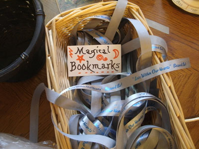 Decorated card, 'Magical Bookmarks', atop silver ribbons in basket