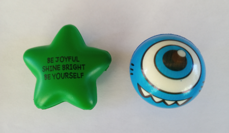 Green star inscribed Be Joyful, Shine Bright, Be Yourself, next to blue globe with goofy cyclops face